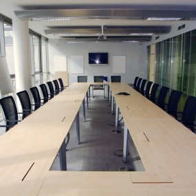 Bilde av langt bord med mange stoler i langt møterom 