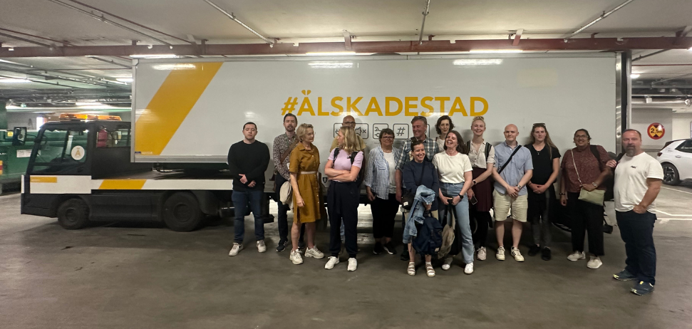 Group photo visiting Älskadestad in Stockholm with the electric delivery truck in the background